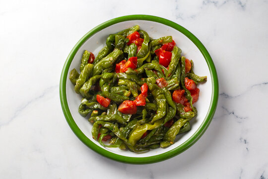 Roasted green friggitello peppers and diced tomatoes served - Turkish name; Biber kizartmasi