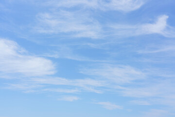Naklejka premium Clear blue sky with soft white clouds scattered throughout, creating a serene and tranquil atmosphere ideal for backgrounds or nature-themed projects