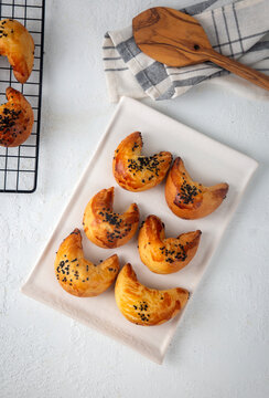 Freshly baked Turkish ay coregi crescent pastry with chocolate filling and black cumin seeds on plate