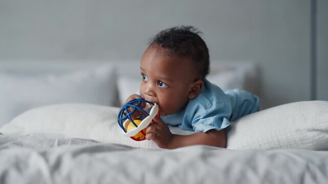 Funny black child exploring world and playing with toy in bedroom, childhood. Safety educational toys for children, development and parenting, african american infant boy or girl, teething period