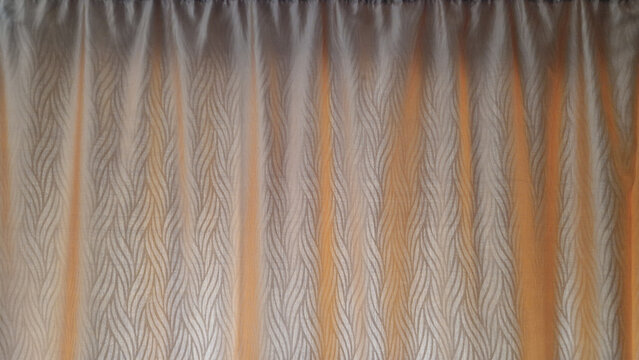 Beige window curtain textile background close up with abstract wave pattern