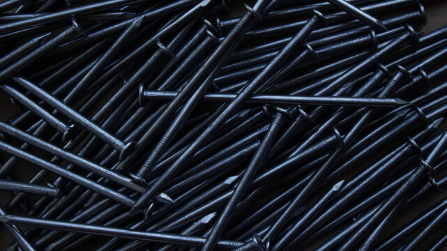 Metal nails heap close up as abstract industrial construction background