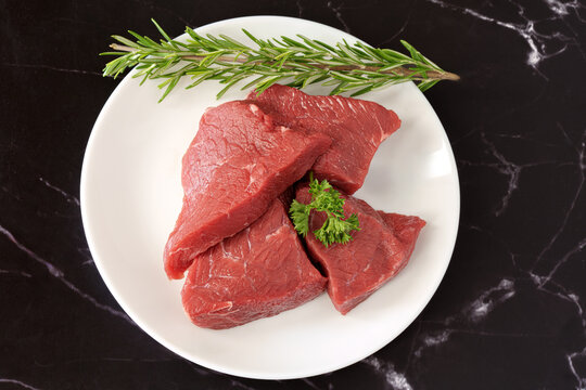 rumsteck de boeuf cru sur assiette blanche