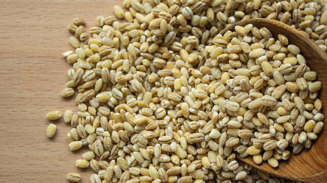 Raw wheat grains texture background top view. Whole organic grain kernels close up. Agricultural cereal crop pattern, healthy dietary food, brewing and culinary ingredient concept