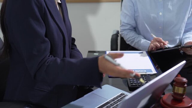 HR manager and legal advisor updating remote work policy on screen Laptop computer.