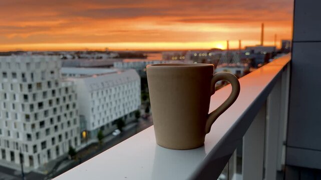 Warm Cup of Tea on Balcony Overlooking City at Sunset