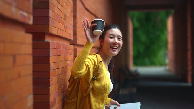 Happy University Student Reading Book with Coffee Leaning Against Brick Wall Campus Outdoors