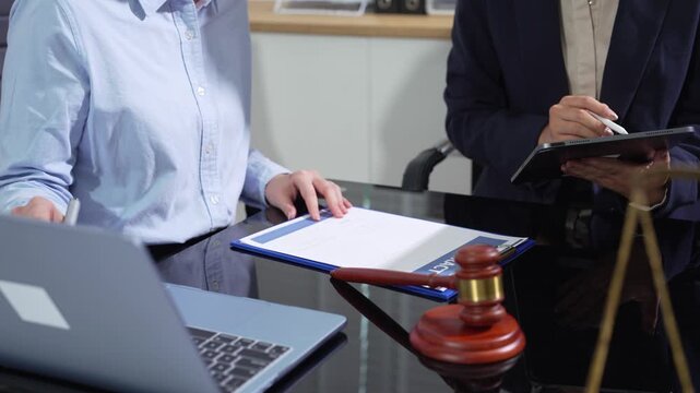 Lawyers review tablet chat messages during a defamation lawsuit, examining social media evidence, digital communication, and legal strategy.