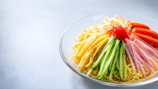 Close-up of hiyashi chuka cold ramen with colorful toppings in glass bowl