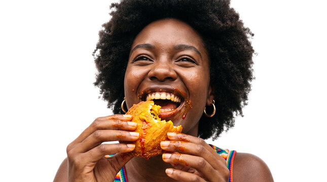 Joyful woman eating a ripe mango outdoors. Happy African female enjoying fresh tropical fruit in natural daylight.