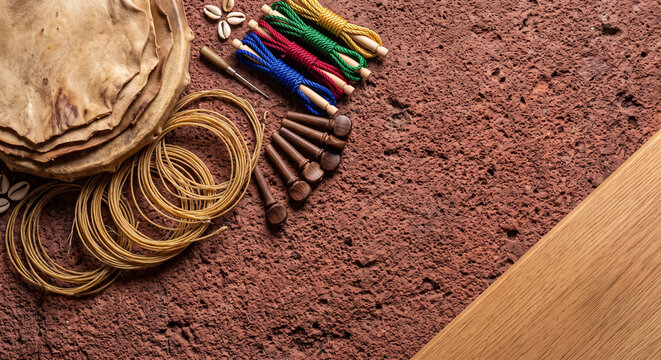 Hyper-realistic top down view of Gnawa Guembri lute tools on stone wall carving