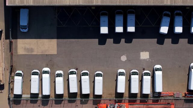 Top-Down Aerial View of White Work Vans Parked in Industrial Yard
