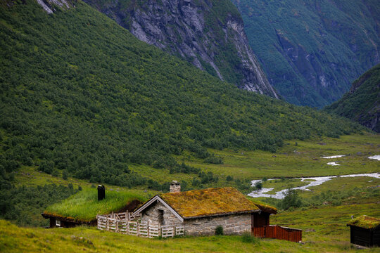 Traditional Norwegian mountain cabins with grass roofs in a scenic valley