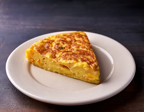 traditional spanish tortilla de patatas with golden crust and soft potato interior classic homemade omelette served on a white plate simple and delicious authentic spanish dish