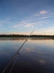 Fototapeta premium Fishing on a lake. Rod against sunset. 