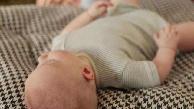 Adorable baby smiling and playing on a soft blanket in cozy indoor setting