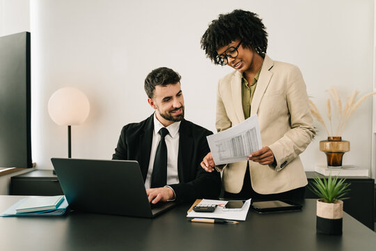 African American businesswoman presenting financial documents during a professional office meeting, reviewing positive results 