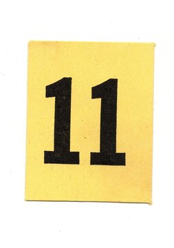 A vintage yellow number card isolated on a white background.