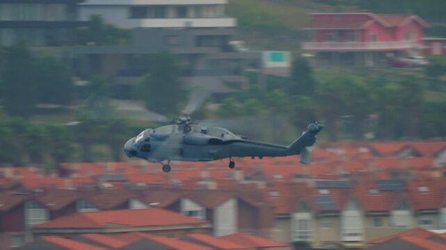 GIJON, SPAIN - JULY 27, 2025: Spanish Navy SH-60B Seahawk maritime helicopter performs a fast low pass over Gijon during the Festival Aereo Internacional airshow