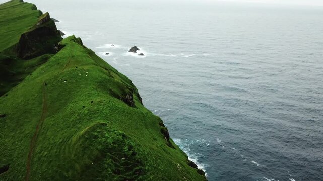 Ocean and green hills, Faroe Islands. Natural landmark of Mykines Island
