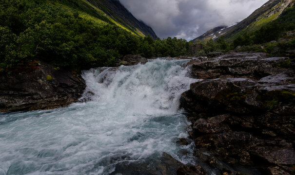 Mountain waterfall flowing through rocky valley in Norway