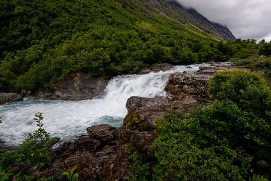 Mountain waterfall flowing through rocky valley in Norway