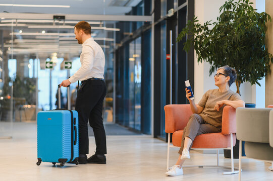 Bellboy assisting guest in hotel lobby with luggage