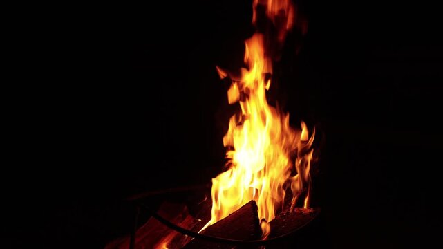Close-up of vibrant orange flames dancing in a dark night setting