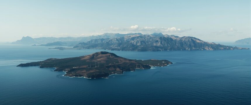Aerial view of a distant island and mountains in the ocean