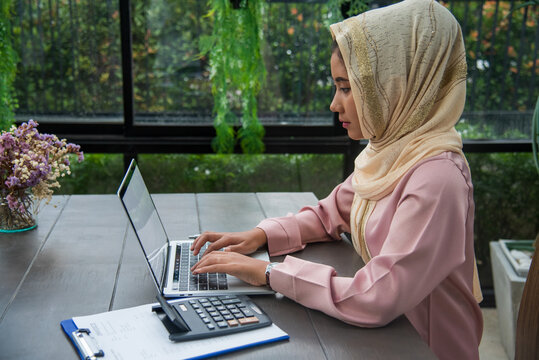 Muslim women working. Young Asian arabian muslim women working summary report business graph chart. Crop arabian muslim women working business report graph chart. Portrait woman wear hijab smile