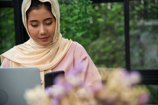 Muslim women working. Muslim woman wear hijab work from home office typing laptop keyboard on wooden desk office supply happy smiling face. Muslim woman wear hijab work from home office typing