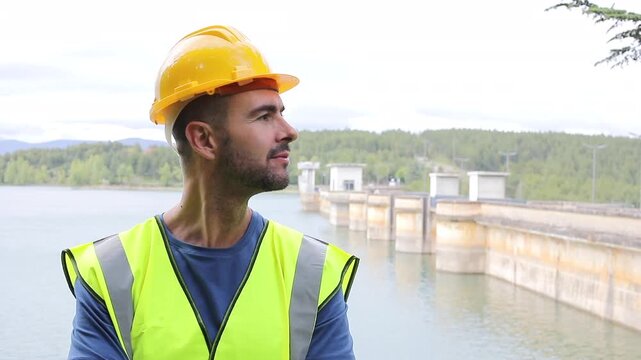 Handsome Dam Employee Wearing Safety Vest and Yellow Hardhat 