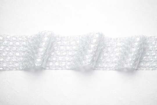 Transparent Bubble Wrap Rolled on White Background with Soft Texture