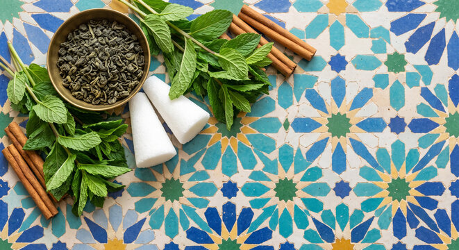 Cinematic top down view of Moroccan Mint Tea ingredients on geometric Zellij tile