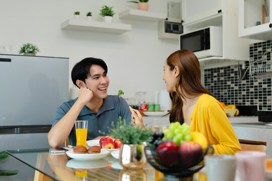 Asian couple enjoy eating together in kitchen room