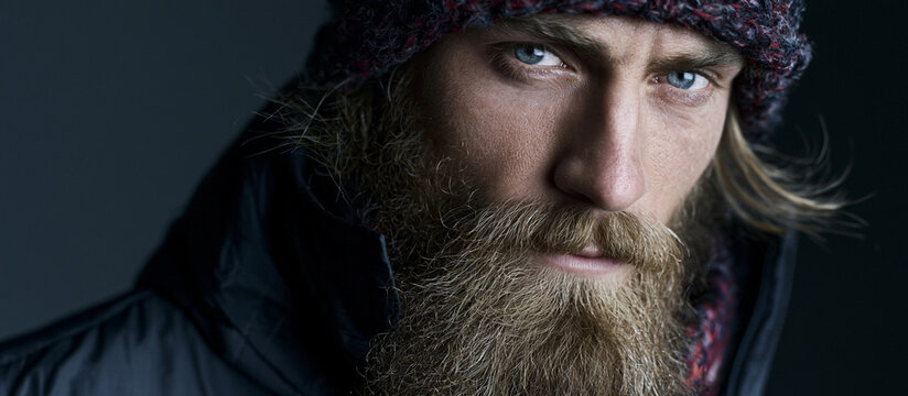 Mature man with full beard in stylish winter coat portrait. Confident bearded male model showcasing rugged masculine fashion close-up.
