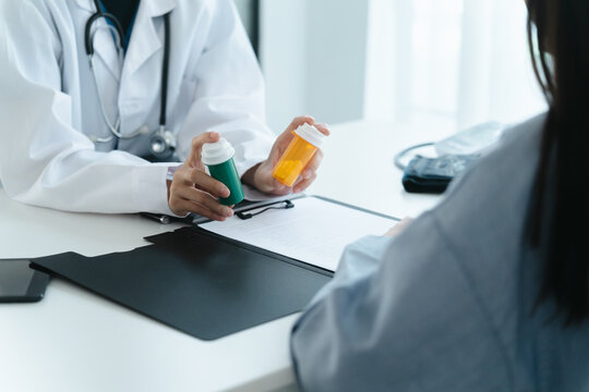 doctor clarifies a drug bottle to a patient in hospital consultation