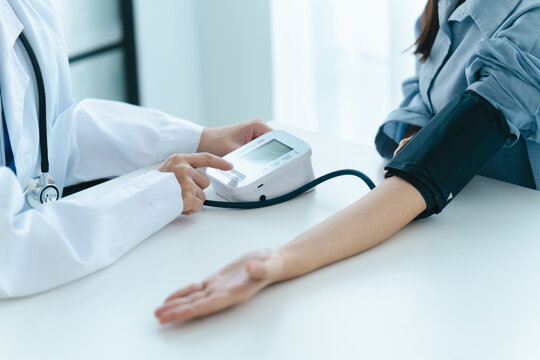 physician checks a patient blood pressure in a medical consultation room