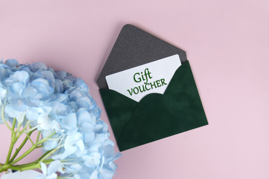 Gift voucher in a green envelope on a light background