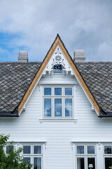 Traditional Scandinavian White Wooden House with Ornate Dormer Window and Fish Scale Roof Tiles © Thorsten