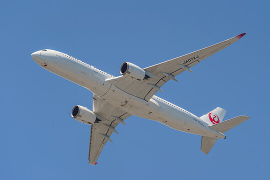 A Japan Airlines (JAL) Airbus A350 in a clear blue sky on July 28, 2024 in Fukuoka, Japan.