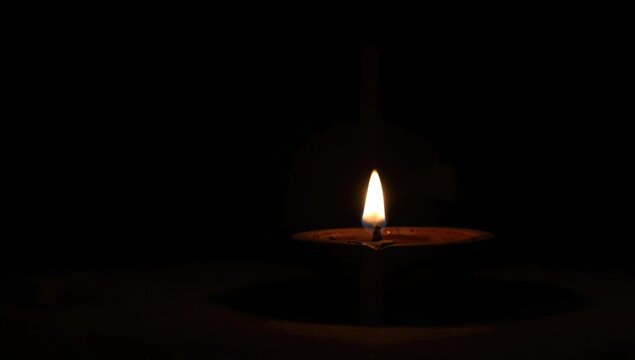 Single Candle Flame Glowing in Darkness with Soft Light