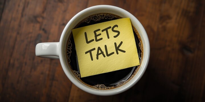 Coffee cup with a yellow sticky note saying "Lets talk"