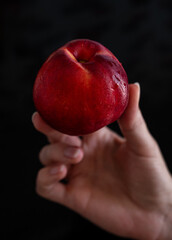 Woman Holding Fresh Ripe Nectarine on Black Background, Healthy Organic Fruit Close Up © Natalia
