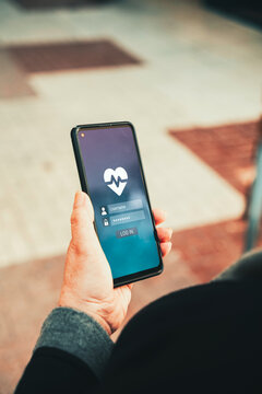 Health App Login Screen on Smartphone Held by Woman's Hand Outdoors. Digital healthcare, telemedicine, mobile wellness tracking, and cybersecurity in health tech concept.