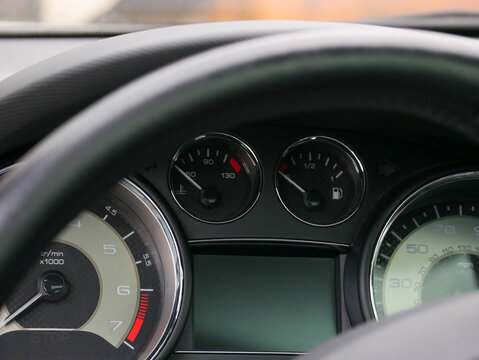 Car dashboard with speedometer and fuel gauge. Modern vehicle cockpit interior showing engine temperature and tachometer. Auto diagnostic panel for driving monitoring and navigation.