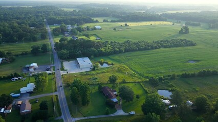 Early morning in Tennessee countryside with country road and homes in rural America beside green pastures and farmland © Steve Tanner Stock