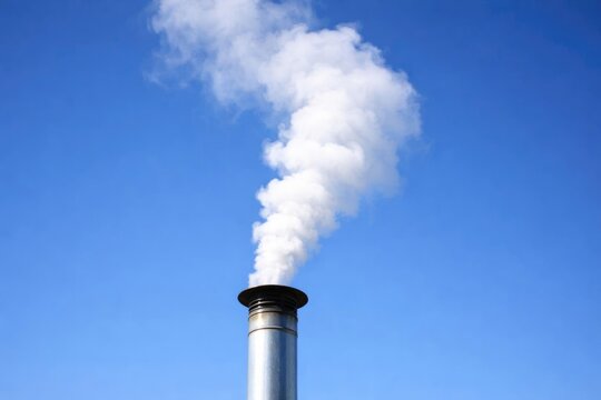 Smoke Emitting from a Metal Chimney Against a Clear Blue Sky