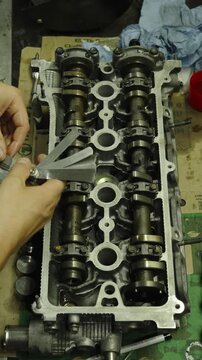 Mechanic holding a feeler gauge set to measure engine clearances.