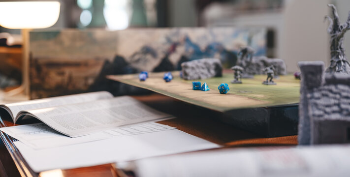 Dungeon master screen with dice and miniatures for role playing tabletop and board games hobby